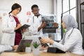 Qualified multi ethnic doctors cooperating during meeting Royalty Free Stock Photo