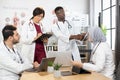 Qualified multi ethnic doctors cooperating during meeting Royalty Free Stock Photo