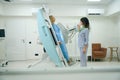 Qualified radiographer preparing adult lady for diagnostic radiography