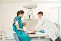 Qualified radiographer preparing toddler for x-ray of lower extremity
