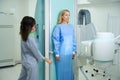 Qualified radiologic technologist preparing lady for radiography