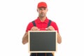 Qualified repairman offers his services. male worker in cap hold blackboard. board for copy space. builder service