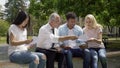 Qualified teacher giving tests to multiracial students in park near university
