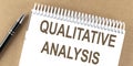 QUALITATIVE ANALYSIS text on a notepad with pen, business concept Royalty Free Stock Photo