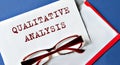QUALITATIVE ANALYSIS - words on a white sheet with an envelope and glasses on the background Royalty Free Stock Photo