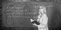 Qualities that make good teacher. Principles can make teaching effective. Woman teaching near chalkboard in classroom Royalty Free Stock Photo