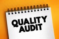 Quality Audit - systematic examination of an organization`s quality management system, text concept on notepad