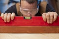 Quality control. Carpenter with spirit level checking the level of a plank of wood Royalty Free Stock Photo