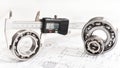 Quality control in modern mechanical engineering - caliper gauges, technical drawing and ball bearings on white background Royalty Free Stock Photo