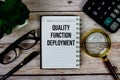 Quality Function Deployment (QFD) text on notepad, Business and Financial concept background