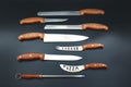 Quality Kitchen Knives. Set of various kitchen knives arranged on black, top view Royalty Free Stock Photo