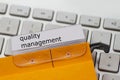 Quality management as a term on a tab on a hanging file Royalty Free Stock Photo