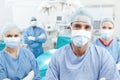 Quality medical care. Portrait of a medical team of surgeons standing together in an operating theatre before surgery. Royalty Free Stock Photo