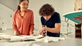 Quality never goes out of style. Young male designer cutting white fabric textile in a studio. Group of creative Royalty Free Stock Photo