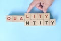Quality over quantity concept. Hand changing word quantity to quality on wooden blocks. Royalty Free Stock Photo