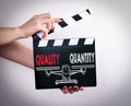 Quality and Quantity Balance. Female hands holding movie clapper Royalty Free Stock Photo