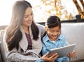 Quality time meets screen time. an adorable little girl using a digital tablet with her mother on an autumn day outdoors Royalty Free Stock Photo