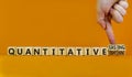 Quantitative easing or tightening symbol. Businessman turns cubes changes words Quantitative easing to Quantitative tightening.