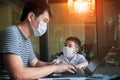 Quarantine asian man and children wearing protection mask working on computer at home selected focusing on children face