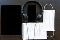 Quarantine, COVID-19, black tablet, black headphones, white hands holding a pen, writing on a white sheet, learning remotely, onli