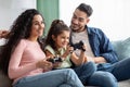 Quarantine Leisure. Young Middle Eastern Family With Daughter Playing Video Games Royalty Free Stock Photo