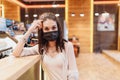 Quarantine rate in a cafe, a young woman in a black mask. Royalty Free Stock Photo