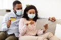 Black couple in medical mask using tablet and credit card Royalty Free Stock Photo