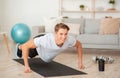 Quarantine sport. Muscular guy doing push-up exercises on fists