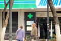 Quarantine times People in a nearly empty street in wearing masks in front of pharmacy