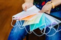 Quarantined woman choose colorful surgical masks to wear to prevent the spread of the CoronavirusCovid-19 Beautiful multi