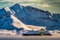 Quark Expeditions tour liner in front of a snowy jagged mountain near Svalbard, Norway