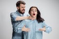 The quarrel men and women. Man strangling a woman on gray background Royalty Free Stock Photo