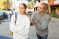 Quarrel between mom and teenage daughter on street. Mom asks for forgiveness Royalty Free Stock Photo