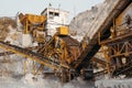 Quarry machines and piles of gravel over blue sky. Stone crushing and screening plant Royalty Free Stock Photo