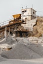 Quarry machines and piles of gravel over blue sky. Stone crushing and screening plant Royalty Free Stock Photo