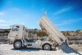 Quarry truck unloads white limestone gravel to crushed stone quarry