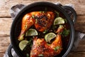 Quarter chicken leg baked with tamarind sauce and lime closeup in a pan. horizontal top view