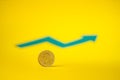 Quarter dollar coin on yellow backdrop. Blurred green arrow in the background. Saving money for the future Royalty Free Stock Photo