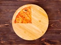 Quarter of pizza with mozzarella, bocconcini and basil leaves or pizza margherita on round wood plate which is on wood Royalty Free Stock Photo