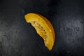 Quarter of a pumpkin on a black stone table, top view