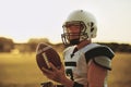 Quarterback standing with a football on a sports field Royalty Free Stock Photo