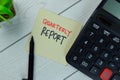 Quarterly Report write on sticky notes isolated on Wooden Table