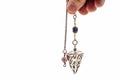 hand holding and using amethyst crystal pendulum on silver chain Royalty Free Stock Photo