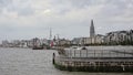 Quay along river Scheldt, with apartment buildings and cathedral in scaffolding in Antwerp