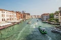 Quay of a Grand channel with cargo boats, river trams, boats. Along the canal there are Venetian houses.