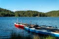Quay with kayaks on a lake and mountain landscape with forest and blue sky with clouds, Shiroka Polqna Royalty Free Stock Photo