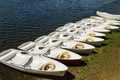 On the quay, rowing boats moor in a row, in every lifeguard and paddles Royalty Free Stock Photo