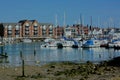 Quayside lifestyle. Moored sail & motor boats & luxury apartments. River Arun, Littlehampton, Sussex, UK Royalty Free Stock Photo