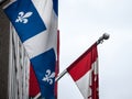 Quebec flag standing in front of the official flag of Canada in Montreal, the main city of Quebec, Royalty Free Stock Photo