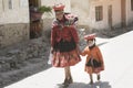 Quechua Indian Woman And Her Granddaughter Dressed In Colorful Handwoven Outfit